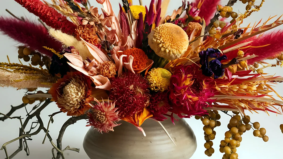 A rustic arrangement of burnt-orange dahlias and dried wheat stalks.
