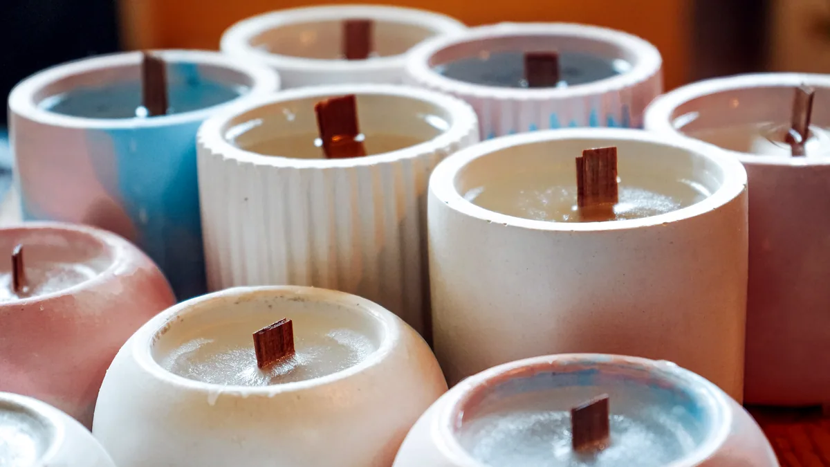 A neat row of finished soy candles in amber glass jars.