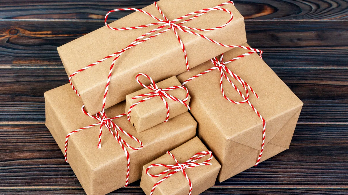 Three small handmade gift boxes tied with twine on a wooden table.